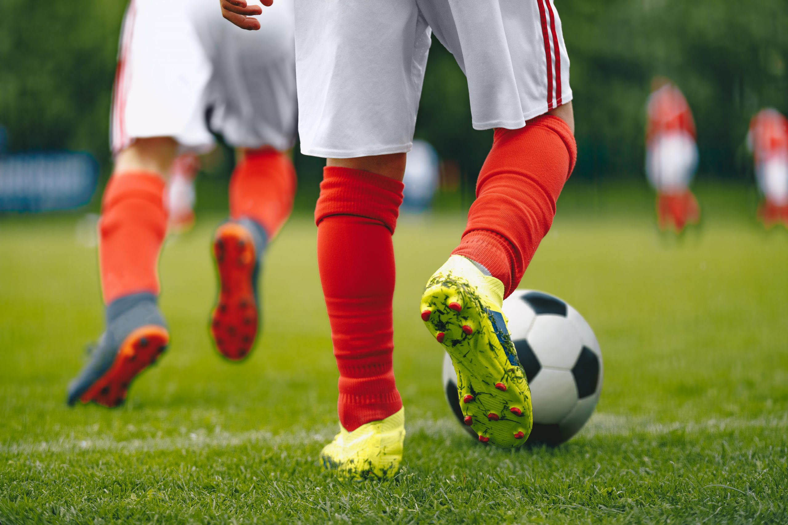 Football/Soccer Running with the Ball. Soccer Player Training on the Field. Close-up View of Soccer Ball and Player Leg